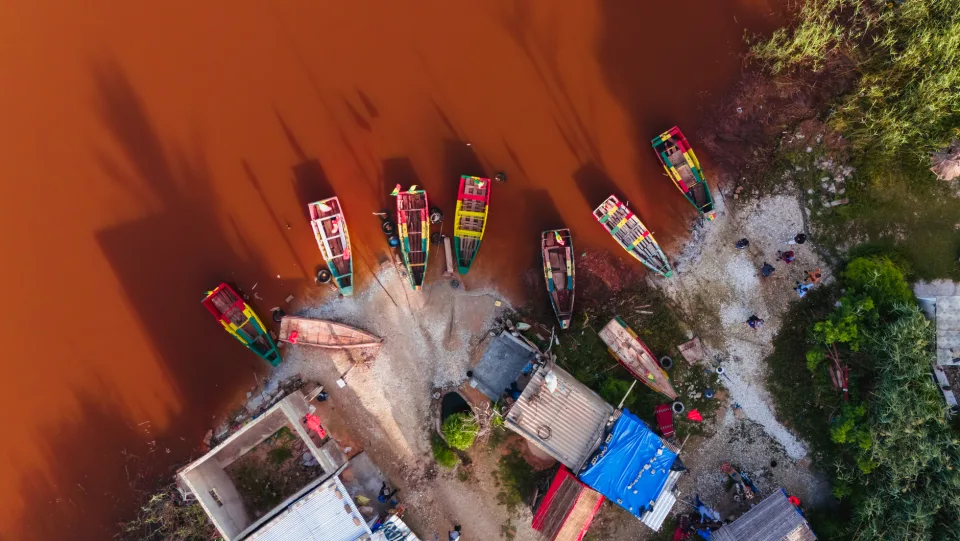Pirogues colorées amarrées sur une rive, vues du ciel
