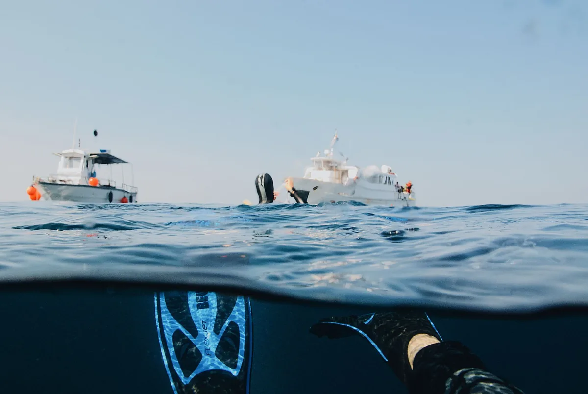 Un bateau de plongée amarré au large, mer calme.