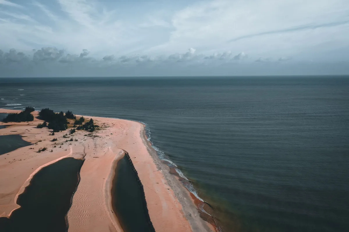 Une île vue du ciel, cernée d’eau turquoise.