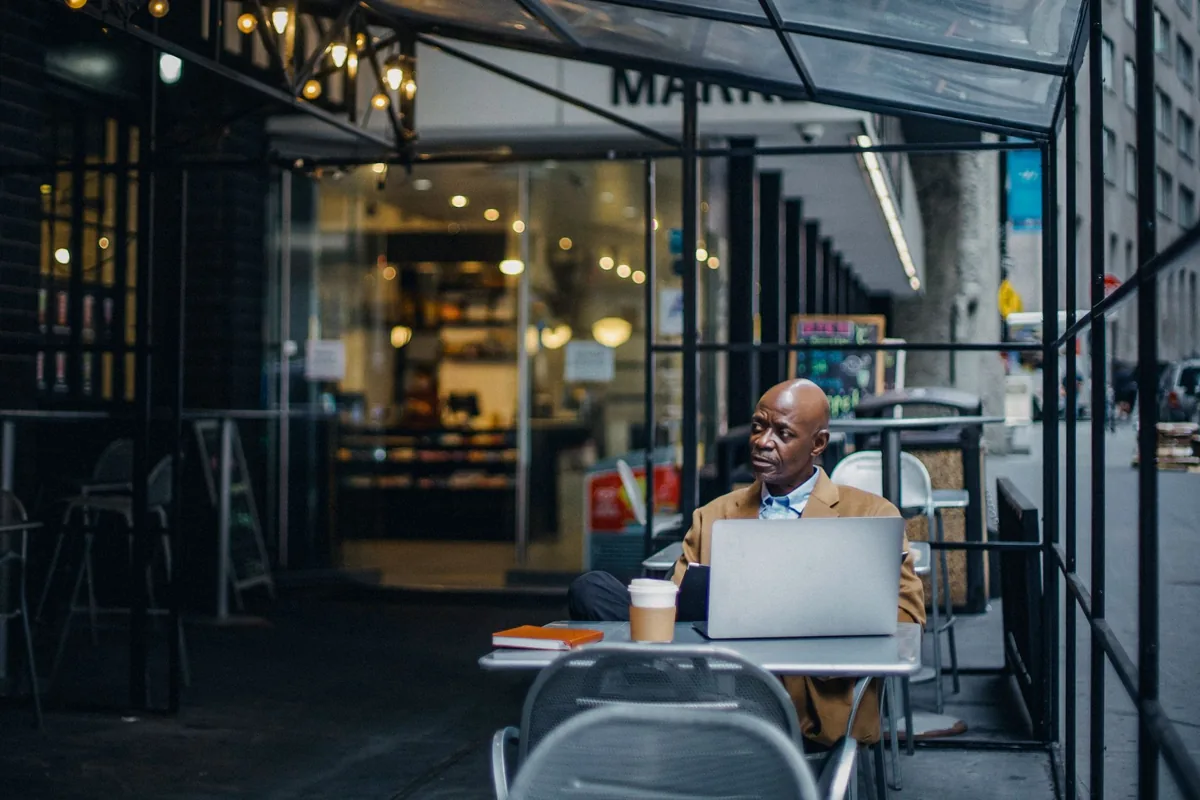 Un ordinateur portable ouvert à la terrasse d’un café.